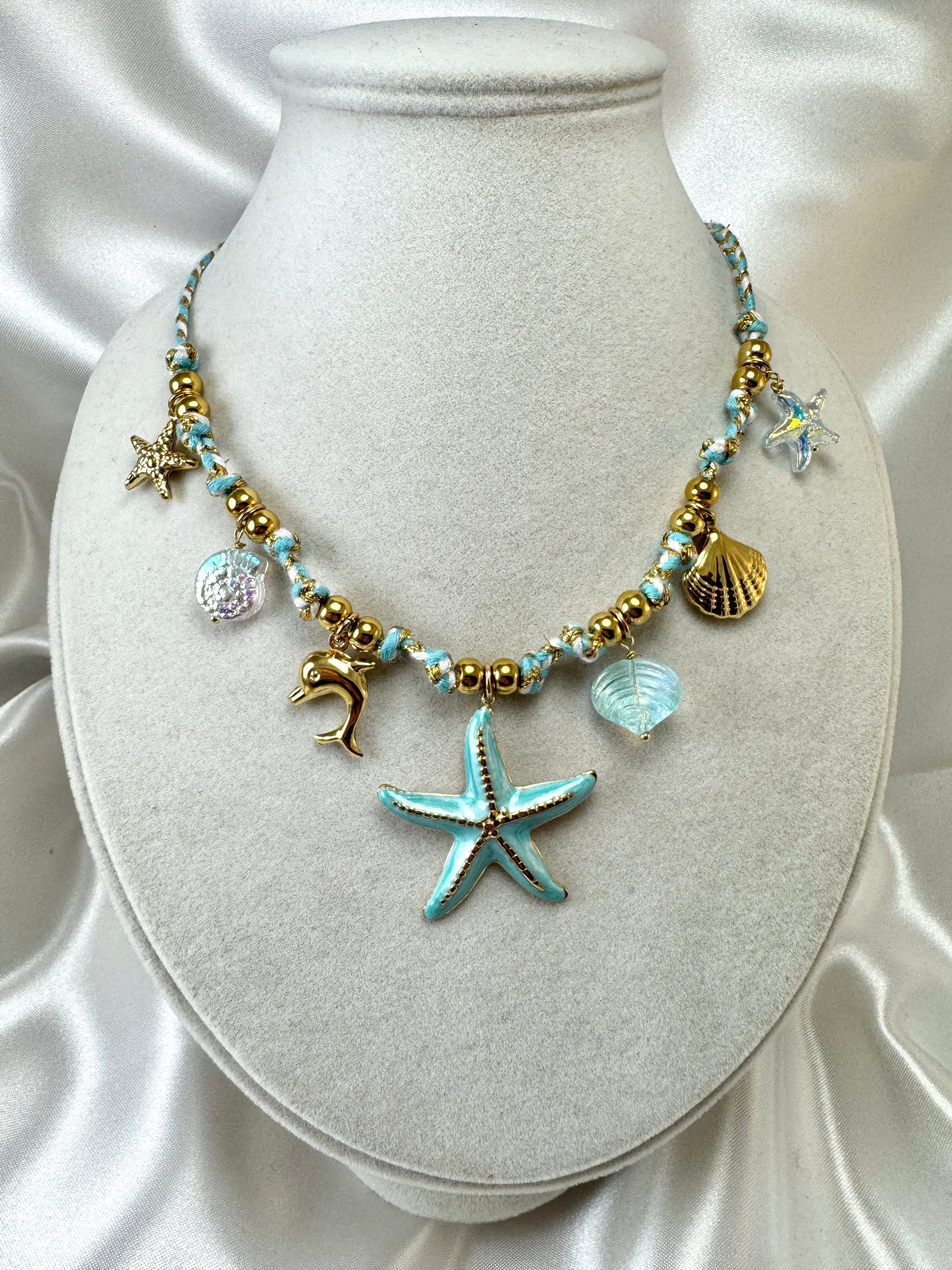 Collana in corda azzurra con ciondoli marini iridescenti