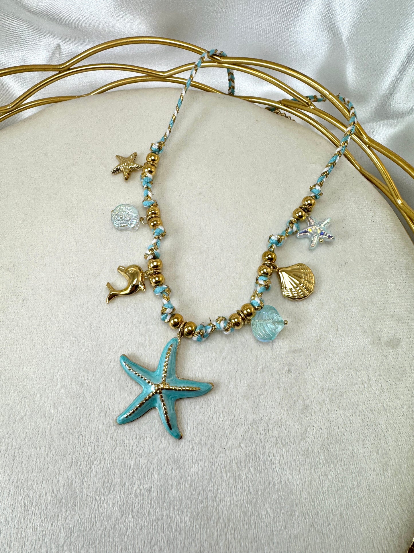 Collana in corda azzurra con ciondoli marini iridescenti