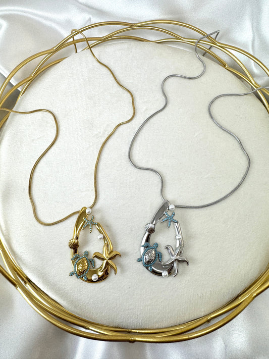 Collana lunga con ovale e ciondoli marini