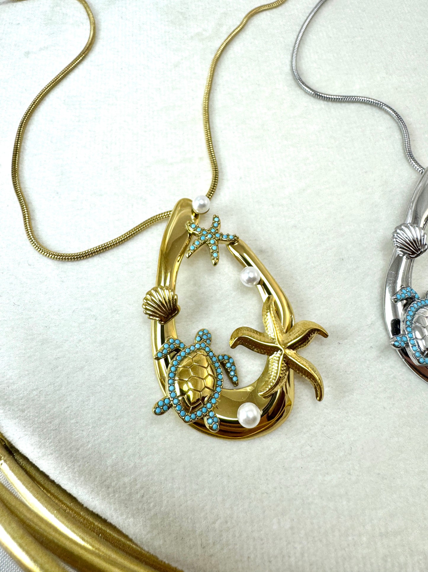 Collana lunga con ovale e ciondoli marini