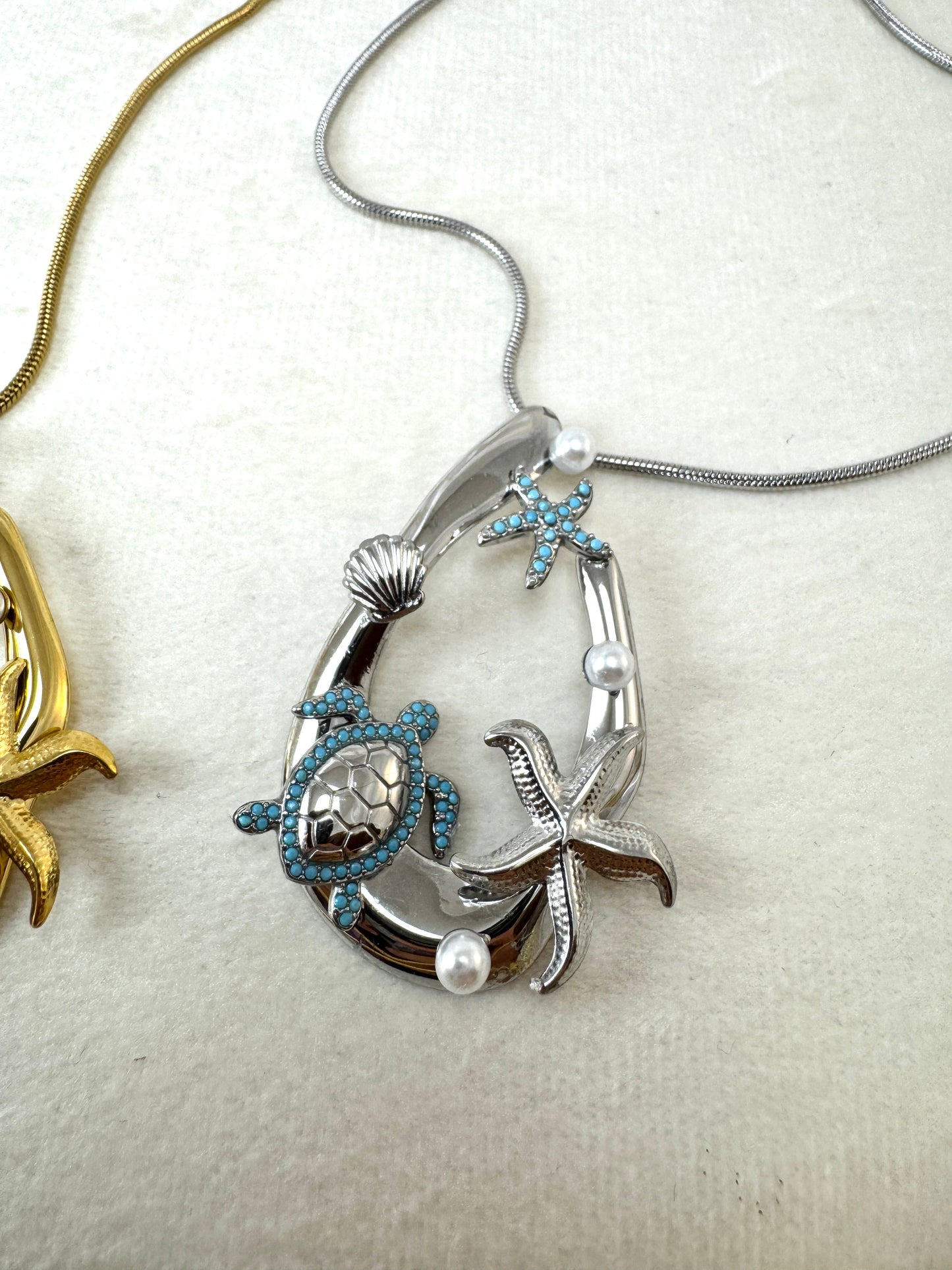 Collana lunga con ovale e ciondoli marini