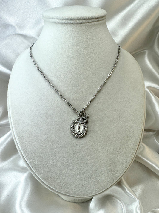 Collana con medaglia, occhio e croce