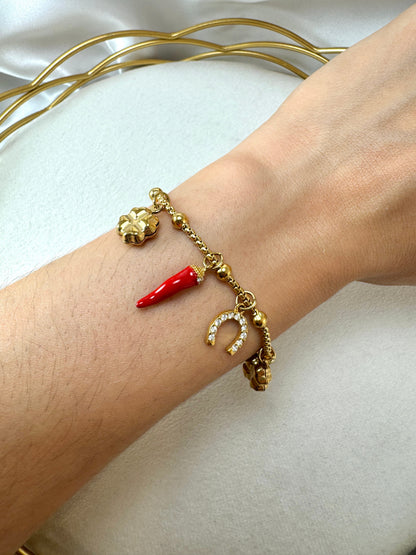 Bracciale con corno, ferro di cavallo, quadrifoglio e ciondoli