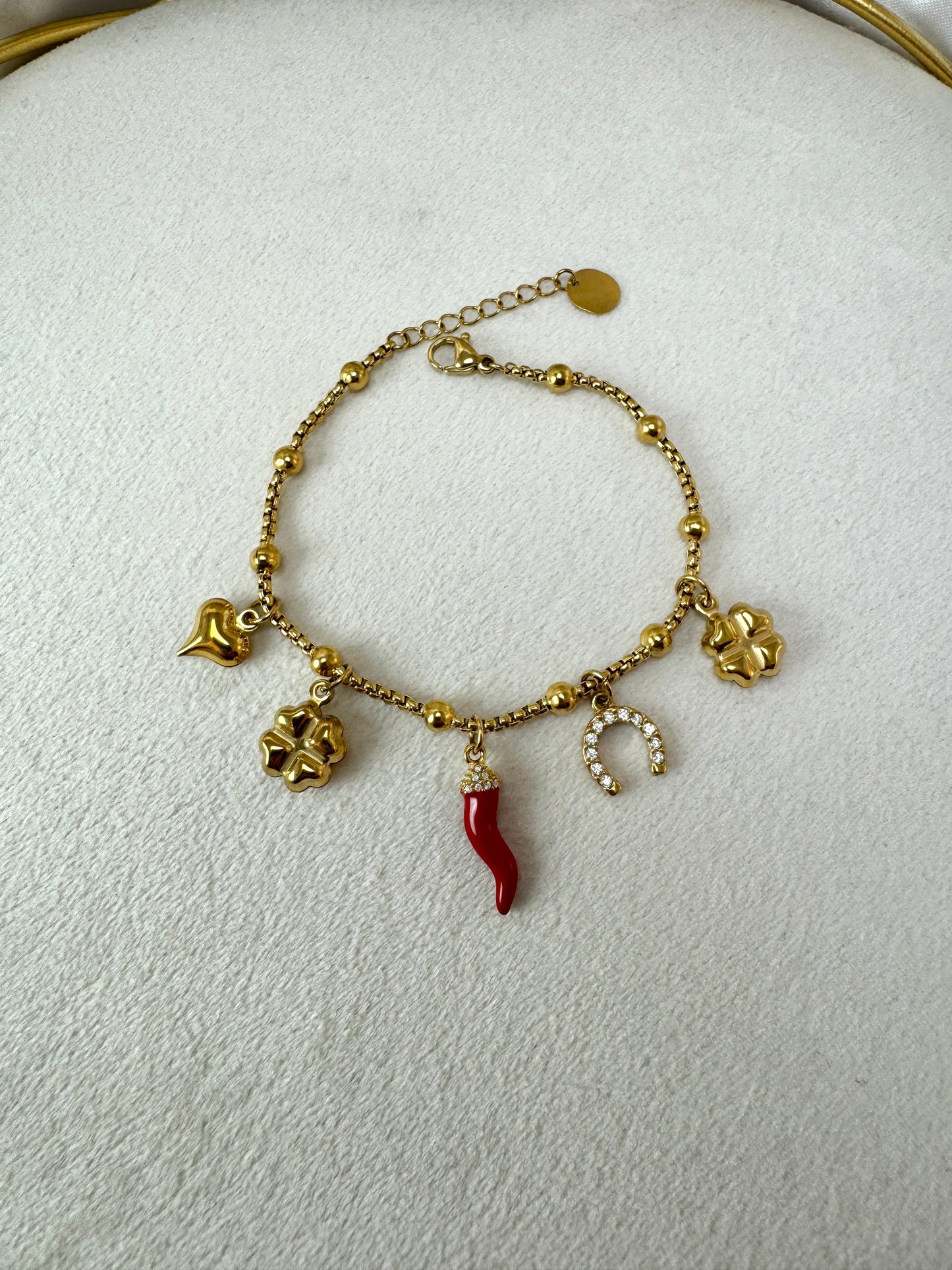 Bracciale con corno, ferro di cavallo, quadrifoglio e ciondoli