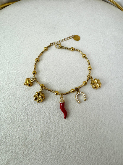 Bracciale con corno, ferro di cavallo, quadrifoglio e ciondoli